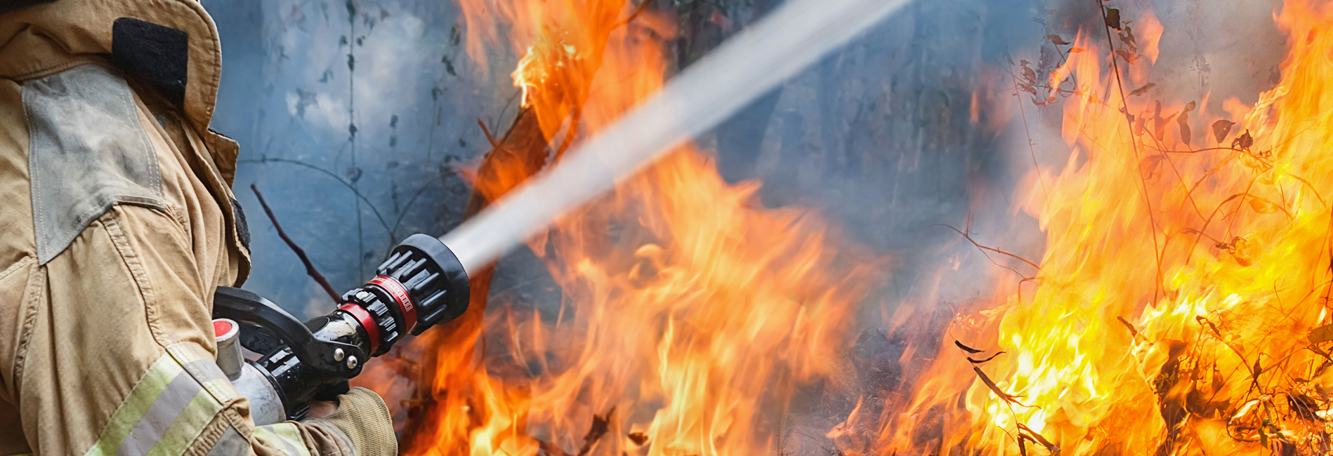 Firefighter fighting fire with water